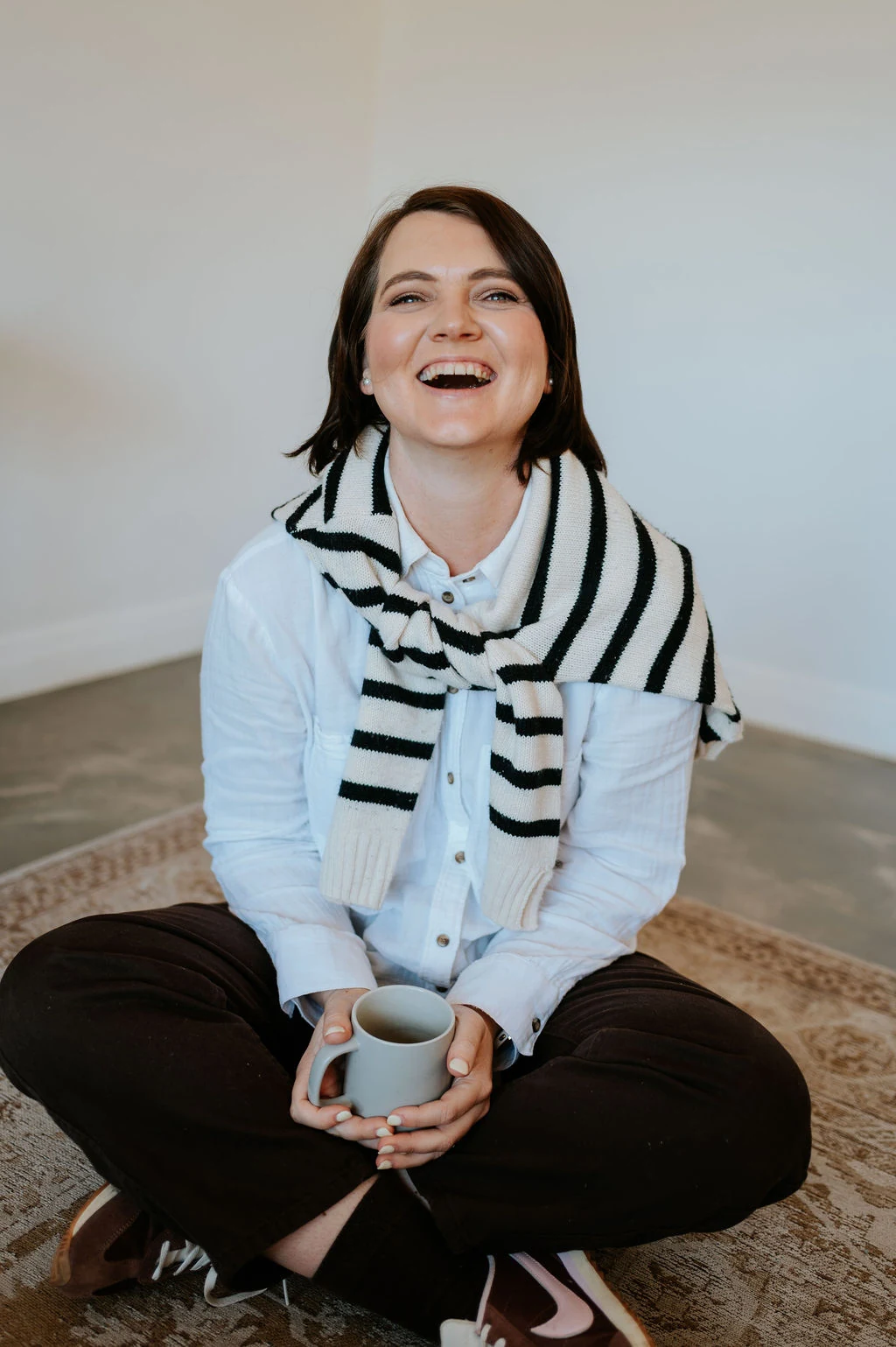 Mia Stultz, founder of Sleep Journey, seated and smiling with a mug